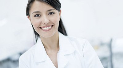 mujer morena con bata blanca sonriendo